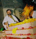 The Chief Priest makes offerings of ghee into the fire.